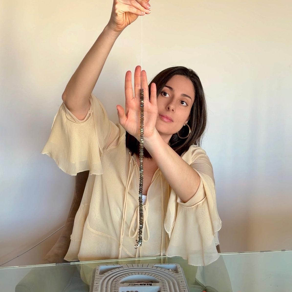 Person taking a mirror selfie with a model architectural structure on a table.